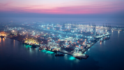 night scene of commercial port load unloading cargo from container ship import  export by crane for...