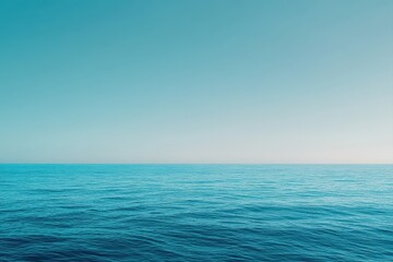 Obraz premium Calm, serene ocean meets a clear, tranquil sky. Horizon line divides two shades of blue, creating a peaceful scene