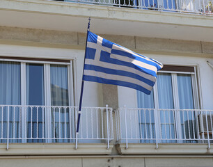 Blue Greek Flag with Cross flying at Balcony  in Thessaloniki, Greece