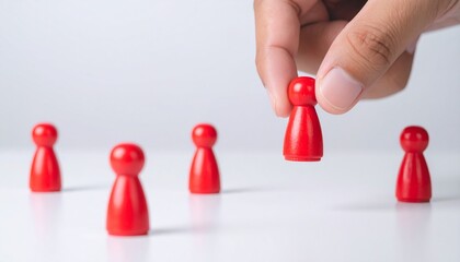 human hand selecting a red figure from group of figure