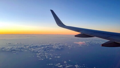 Obraz premium Aerial sunset views from airplane wing above the clouds travel photography serene atmosphere wide angle perspective dreamy skies