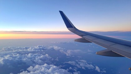 Obraz premium Airplane wing above clouds at sunset aerial view travel photography serene atmosphere dynamic landscape
