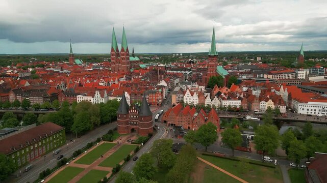 aerial shot around lubeck city center with the holstentor gothic gate in the foreground and the city center with churches in the background, Lubeck city, Schleswig-Holstein land, Germany