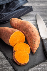 Raw sweet potatoes on kitchen table.
