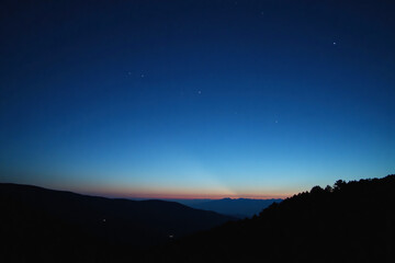Mountain range silhouetted peaceful against twilight sky represents solitude