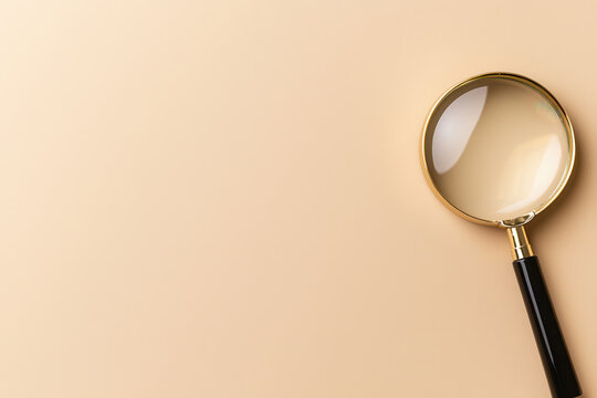 Magnifying glass rests on smooth surface, emphasizing clarity and focus. This tool symbolizes investigation and detail