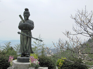 Obraz premium 日本：梅の花と銅像（605年繖山山頂に聖徳太子が創建した観音正寺）【観音寺城跡・国指定史跡】滋賀県近江八幡市安土町