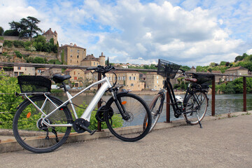 Vélos devant la rivière, arrière plan sur le village médiéval touristique
