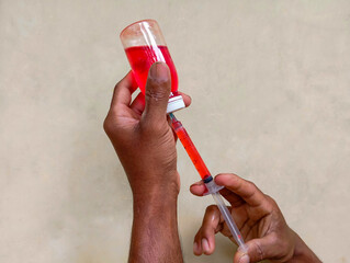 injection and red liquid in a bottle