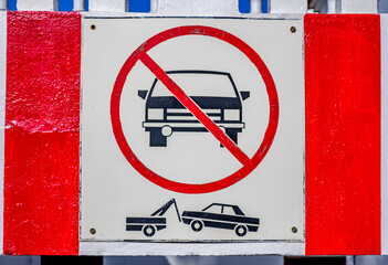 No parking sign indicating permanent towing zone for vehicles in urban area in bright sunlight