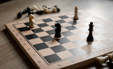 White and black chess pieces on chessboard during the game, close up