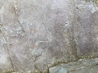 Textured Light Grey Stone Surface with Subtle Green Moss Growth