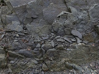 Dark Grey Shattered Rock Surface with Jagged Edges and Small Debris