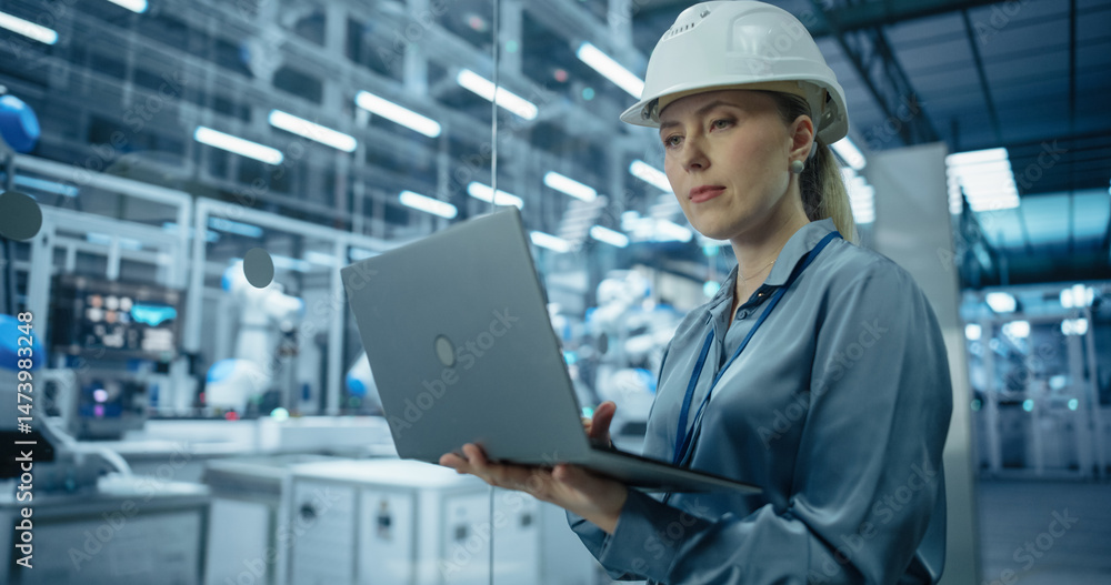 Aufkleber Electronics Factory Manager Working on Laptop at an Industrial Manufacture with Robotic Arms. Female Specialist Monitoring Data on a Computer, Checking and Planning Production Process