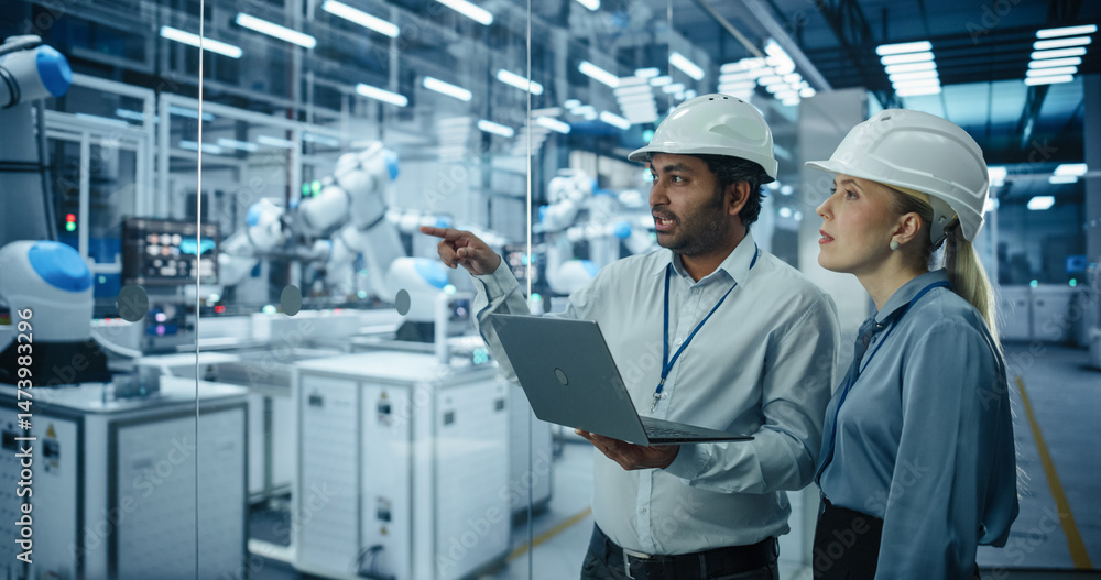 Aufkleber Two Engineers, a South Asian Male and a Caucasian Female, Collaborate Using a Laptop Computer to Optimize Robotic Systems in a Modern Factory, Analyzing Productivity and Automation