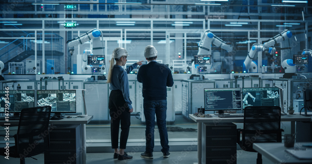 Fototapete Engineer and Technician Standing with Their Back to Camera, Having a Discussion and Using a Laptop Computer. Industrial Specialists Analyzing Conditions at an Electronics Factory with an Assembly Line