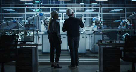 Female and Male Industrial Engineers Having a Conversation at a Modern Tech Electronics Factory...