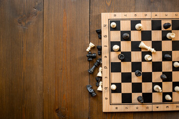 White and black chess pieces on chessboard during the game, top view