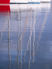 Sailing ship masts reflected in the sea