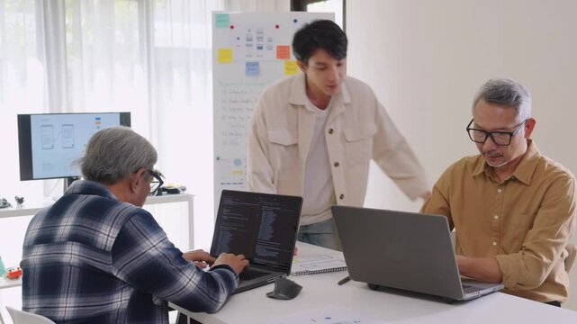 Asian senior bootcamp team asking and  learning programming with software training and whiteboard collaboration