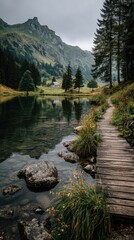 Obraz premium Scenic mountain lake with rustic wooden footbridge and forested hills under overcast sky perfect for travel blogs, adventure campaigns, hiking visuals and peaceful nature backgrounds