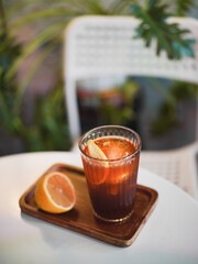Craft Cola. A top view soft focus on a craft cola with round ice ball and a half of lemon on the side. Refreshment during summer. Vintage film grained filter.