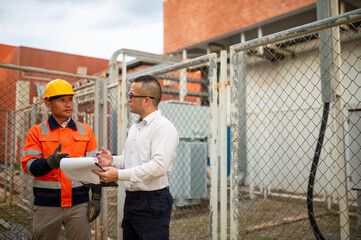 Electrical engineers are checking the performance of electrical transformers in an industrial...