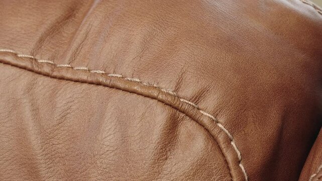Closeup shows heat gun speeding drying of fresh paint on brown leather sofa