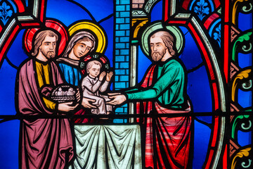 Fototapeta premium Stained glass (19th century) of Childhood of Jesus: Presentation of Jesus in the temple by Mary and Joseph.