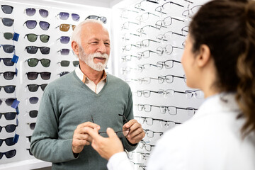 Senior patient consulting experienced ophthalmologist about new pair of eyeglasses.