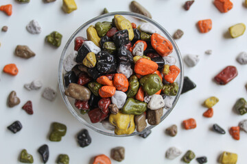 Turkish stone chocolate, in transparent bowl, scattered around, isolated on white background, flat lay or top view
