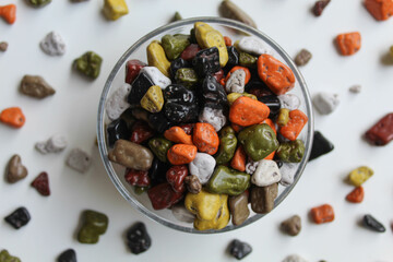 Turkish stone chocolate, in transparent bowl, scattered around, isolated on white background, flat lay or top view