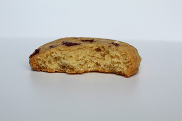 A bitten white choco soft cookie with almond and berry cuts, isolated on white background