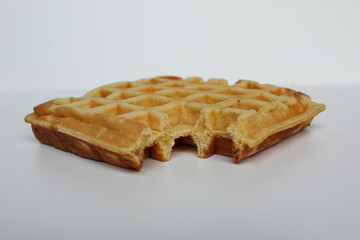 One bitten waffle cake, isolated on white background
