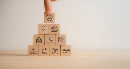 Work safety and compliance concept. Wooden cube blocks with icon of safety at workplace. Safety...