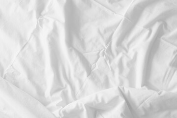 Abstract pattern of white crumpled bed sheet. White wrinkled fabric texture rippled surface. Close up image.