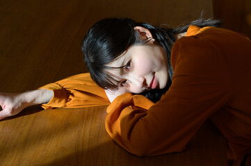 光が差し込むリビングでうつ伏せに寝る日本人女性