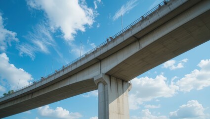 Elevated Concrete Bridge with Pedestrians Under a Blue Sky and Fluffy Clouds in Daylight