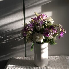 Elegant Floral Arrangement with White Roses and Purple Flowers in Sunlight