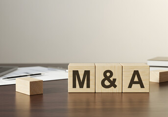 Understanding mergers and acquisitions m and a concept wooden blocks on a desk for business strategy