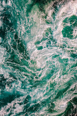 Blue waves of water of the river and the sea meet each other during high tide and low tide.