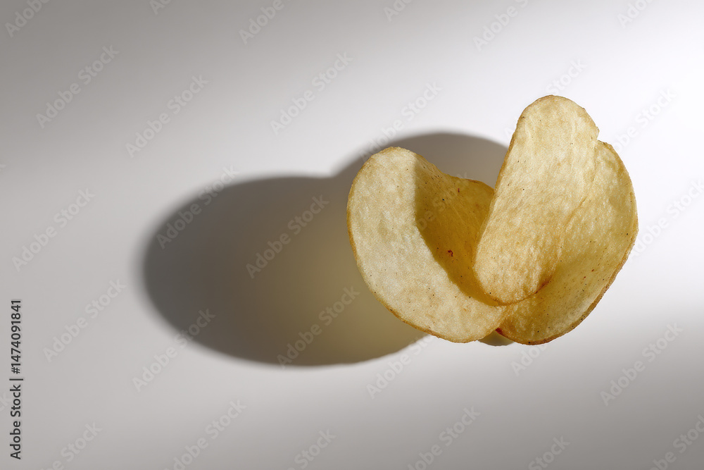 Poster a minimalist image of a single stack of potato chips gracefully balanced, showcasing its crisp textu