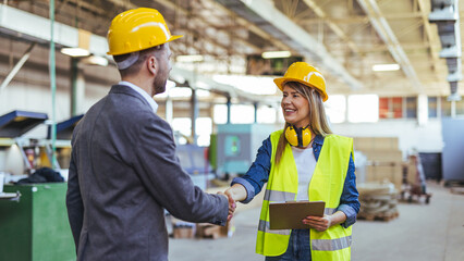 Construction Professionals Shaking Hands in Industrial Setting With Safety Gear and Equipment