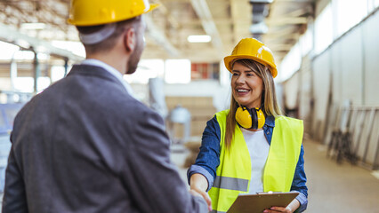Professional Teamwork Between Engineers Shaking Hands on a Factory Floor