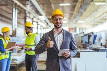 Confident Executive at a Factory Giving a Thumbs Up