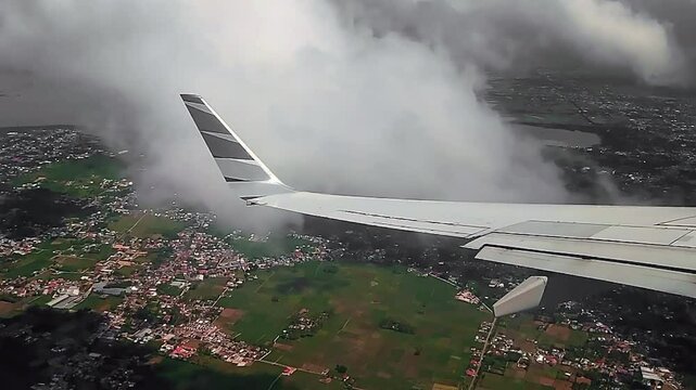 The wing of a commercial airplane flew over beautiful landscape at morning cloud view from the window of the plane. Traveling by air