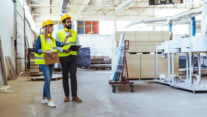 Two Industrial Workers Inspecting a Warehouse Facility While Discussing Logistics