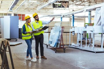 Two Engineers Planning Inside a Factory While Wearing Safety Equipment