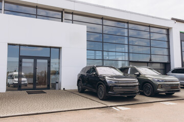 Modern cars parked in front of dealership showroom