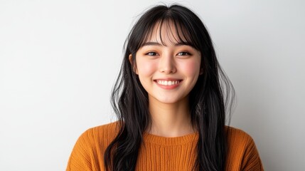 Fototapeta premium The woman, who has long black hair and is wearing a white sweater, is smiling